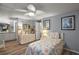 Cozy bedroom with floral bedding, wood-look flooring, and a decorative dresser with a mirror at 150 Hickory Ln, Eustis, FL 32726