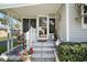 Charming front entrance with steps, a decorated screen door, and well-maintained landscaping at 150 Hickory Ln, Eustis, FL 32726