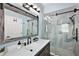 Modern bathroom with a sliding glass shower door, stylish vanity, and a sleek, framed mirror at 1554 Sarus Ave, Groveland, FL 34736