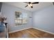 A secondary bedroom has a ceiling fan, a window with blinds, luxury vinyl plank floors, and light blue walls at 1554 Sarus Ave, Groveland, FL 34736