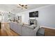 Spacious living room showcasing wood-look floors, a comfortable gray sectional, and a decorative fireplace at 1554 Sarus Ave, Groveland, FL 34736