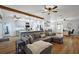 Spacious living room with a large sectional couch, hardwood floors, and abundant natural light at 1554 Sarus Ave, Groveland, FL 34736