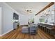 Open-concept living room featuring wood flooring, exposed beam, and seamless flow to kitchen at 1554 Sarus Ave, Groveland, FL 34736