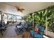 Relaxing screened-in porch featuring comfortable seating and lush greenery views at 1554 Sarus Ave, Groveland, FL 34736