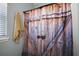 Close-up of shower curtain depicting wood-grained doors and riveted metal accents for a rustic aesthetic at 1554 Sarus Ave, Groveland, FL 34736