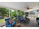 Inviting sunroom with tiled floor and cozy seating, offering a serene view of the lush backyard at 1554 Sarus Ave, Groveland, FL 34736
