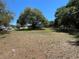 Lush backyard with a screen enclosed patio with a sprawling lawn, complemented by mature trees at 1650 Sundance Dr, St Cloud, FL 34771