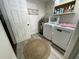 Functional laundry room with wood-look tile, modern washer and dryer, and shelving for storage at 1650 Sundance Dr, St Cloud, FL 34771