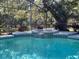 Beautiful screened-in pool area with a spa, lush landscaping, and plenty of space for outdoor relaxation at 1650 Sundance Dr, St Cloud, FL 34771