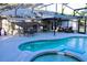 Inviting screened-in pool area with a spa, outdoor dining set, and ample seating for entertaining at 1650 Sundance Dr, St Cloud, FL 34771