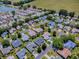 Aerial view of a community with single-Gathering homes and a pond, showcasing the neighborhood layout at 17374 Se 76Th Flintlock Ter, The Villages, FL 32162