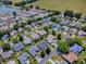 Aerial view of a community with single-Gathering homes and a pond, showcasing the neighborhood layout at 17374 Se 76Th Flintlock Ter, The Villages, FL 32162