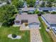 Aerial view of a well-maintained home with beautiful landscaping and a patterned driveway at 17374 Se 76Th Flintlock Ter, The Villages, FL 32162