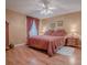 Cozy bedroom featuring a queen-size bed and wood flooring at 17374 Se 76Th Flintlock Ter, The Villages, FL 32162