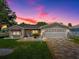 Charming single-story home featuring a manicured lawn and decorative stone driveway at 17374 Se 76Th Flintlock Ter, The Villages, FL 32162