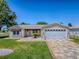 Home exterior with a well-maintained lawn, decorative stone accents, and a patterned driveway at 17374 Se 76Th Flintlock Ter, The Villages, FL 32162