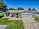 Charming home with well-manicured lawn, palm tree, and decorative stone driveway at 17374 Se 76Th Flintlock Ter, The Villages, FL 32162