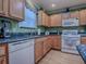Charming kitchen featuring wood cabinets, granite countertops, and stainless steel sink at 17374 Se 76Th Flintlock Ter, The Villages, FL 32162