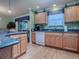 Well-lit kitchen with wood cabinets, granite countertops, and stainless steel appliances at 17374 Se 76Th Flintlock Ter, The Villages, FL 32162