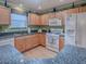Kitchen with wooden cabinets, granite countertops, and appliances at 17374 Se 76Th Flintlock Ter, The Villages, FL 32162