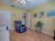 Living room featuring a recliner chair, wood flooring and sunny walls at 17374 Se 76Th Flintlock Ter, The Villages, FL 32162