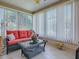 Inviting sunroom with tile flooring, offering an abundance of natural light and comfortable seating at 17374 Se 76Th Flintlock Ter, The Villages, FL 32162