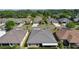 Neighborhood setting with a view of a tan house with a screened-in patio surrounded by well-maintained green lawns at 1754 Pennecamp Dr, The Villages, FL 32162