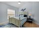 Comfortable bedroom with light blue walls, wood flooring, window, and coastal decor at 1754 Pennecamp Dr, The Villages, FL 32162