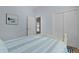 Light bedroom featuring a bed with blue and white striped bedding, closet and 'Beach' wall art at 1754 Pennecamp Dr, The Villages, FL 32162