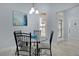 Bright dining area with a glass table, modern chandelier, and natural light from the window at 1754 Pennecamp Dr, The Villages, FL 32162