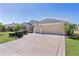 Charming single-story home with a two-car garage, well-manicured lawn, and palm trees in a beautiful community at 1754 Pennecamp Dr, The Villages, FL 32162