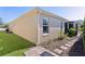 Exterior view of home showing a well-maintained lawn, pathway, and the corner of the screened-in lanai at 1754 Pennecamp Dr, The Villages, FL 32162