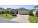 Inviting single-Gathering home boasting a two-car garage, neat landscaping, and a charming curb appeal at 1754 Pennecamp Dr, The Villages, FL 32162