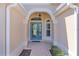 Inviting entryway featuring a glass-paneled front door, decorative archway, and stylish tile flooring at 1754 Pennecamp Dr, The Villages, FL 32162