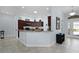 Open kitchen with dark wood cabinets, granite countertops, breakfast bar, and modern appliances at 1754 Pennecamp Dr, The Villages, FL 32162