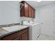 Functional laundry room with sink, cabinets, and modern washer and dryer at 1754 Pennecamp Dr, The Villages, FL 32162