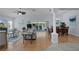 Bright living room featuring hardwood floors, neutral walls, elegant furnishings, and sliding glass doors to lanai at 1754 Pennecamp Dr, The Villages, FL 32162