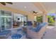 Relaxing screened lanai features wicker furniture, ceiling fan, and sliding glass doors to the bright and airy living area at 1754 Pennecamp Dr, The Villages, FL 32162
