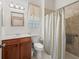 Functional bathroom features a vanity, toilet, and shower with patterned shower curtain at 17787 Se 114Th Ave, Summerfield, FL 34491