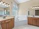 Bathroom with double sink vanity, bathtub, and tiled floors at 17787 Se 114Th Ave, Summerfield, FL 34491