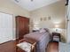 Charming bedroom with a plaid bedspread, wood floors, and matching wooden furniture at 17787 Se 114Th Ave, Summerfield, FL 34491