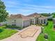 Well-manicured lawn and mature landscaping accent this home with brick-paved driveway at 17787 Se 114Th Ave, Summerfield, FL 34491