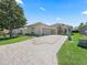 Charming exterior elevation showcasing landscaped curb appeal and brick-paved driveway at 17787 Se 114Th Ave, Summerfield, FL 34491