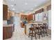 Kitchen featuring a breakfast bar, tile floors, oak cabinets, and stainless appliances at 17787 Se 114Th Ave, Summerfield, FL 34491