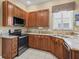 Close up on kitchen featuring granite countertops, stainless appliances, and oak cabinets at 17787 Se 114Th Ave, Summerfield, FL 34491