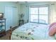 A bright bedroom is accented by a large window, ceiling fan and neutral colored walls at 1806 Estafana Way, The Villages, FL 32159