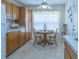 Bright kitchen features honey-toned cabinets, a round breakfast table, and large bright window at 1806 Estafana Way, The Villages, FL 32159