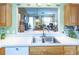 Well-designed kitchen featuring stainless steel sink and breakfast bar overlooking the living area at 1806 Estafana Way, The Villages, FL 32159