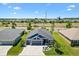 Stunning aerial view of a modern home with lush landscaping, a brick driveway, and a serene pond in the community at 2001 Dagenais Way, The Villages, FL 32163