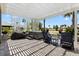 Relaxing outdoor patio with a hot tub, Adirondack chairs and a pergola overlooking the water at 2001 Dagenais Way, The Villages, FL 32163